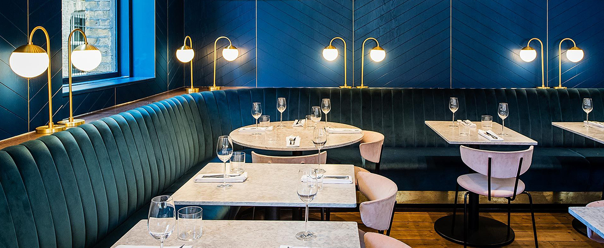 Vintage Industrial Restaurant with Blue Banquette Seating 