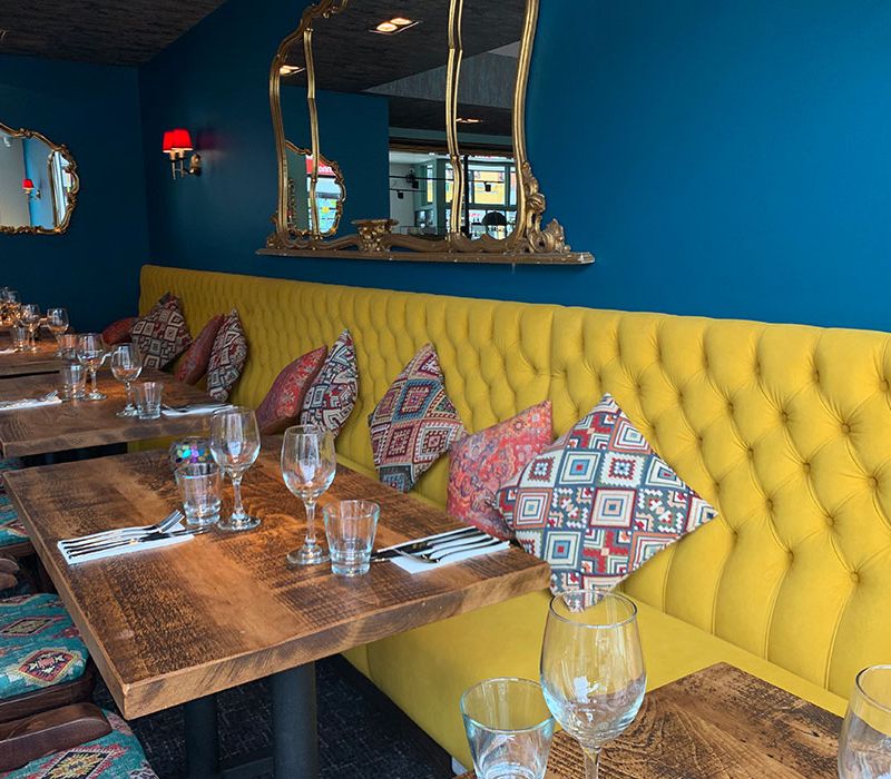 yellow upholstered fixed banquette seating